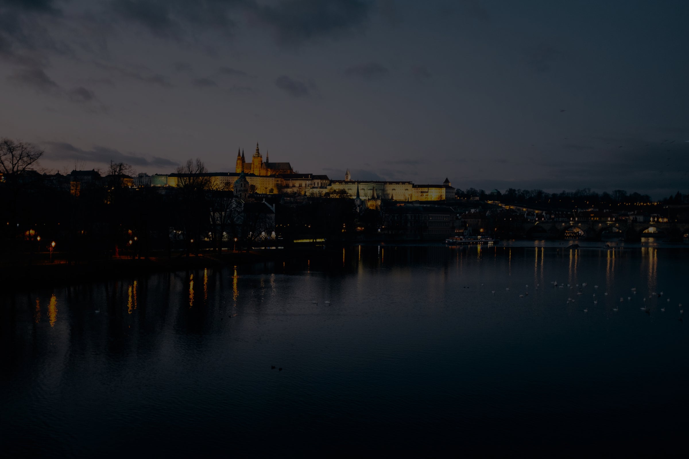 Cityscape at night with illuminated buildings reflected in water